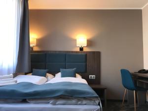 弗罗茨瓦夫Hotel Sleep Wrocław的一间卧室配有一张床、一张桌子和两盏灯。