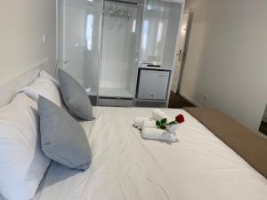 尼科西亚Nicosia 5 Stars Suites的白色的床,花放在碗里