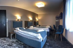 弗罗茨瓦夫Hotel Sleep Wrocław的一间酒店客房,房间内设有四张床