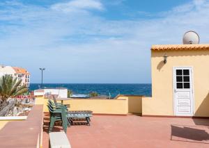 圭马尔港Casita de playa的一个带长椅的庭院和背景海洋