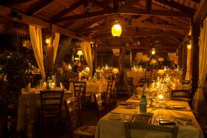 坎帕拉科洛洛别墅的餐厅配有白色的桌椅和灯光