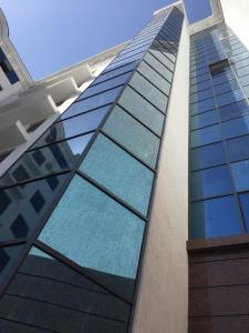 撒马尔罕New apartment in new building的一座高大的建筑,设有蓝色的玻璃窗