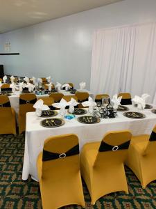 塔拉迪加经济套房旅馆 - 塔拉迪加的一组桌椅,配有白色的桌布