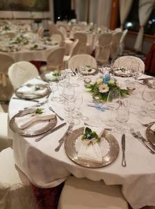 博尔塞纳Platani Hotel的一张长桌,上面有白色的桌子,上面有盘子和银器