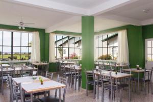 费德拉西翁IRUPÉ APART HOTEL的餐厅设有桌椅和绿色的墙壁