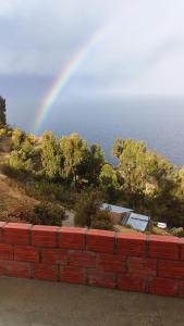 Isla de SolLas Cabañas Lodge的海边砖墙上的彩虹