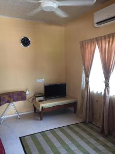 Kampong TelokAMIMAS HOMESTAY的一间带电视和窗户的客厅