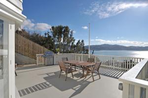 惠灵顿Incredible Views! Luxurious Studio & Outdoor Living的享有水景的天井配有桌椅