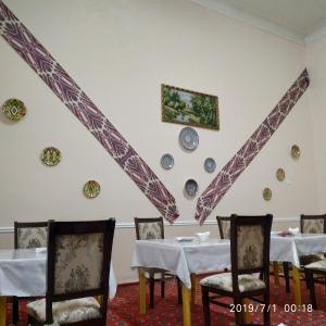 希瓦Mubina Khiva B&B的墙上设有餐桌和盘子的用餐室