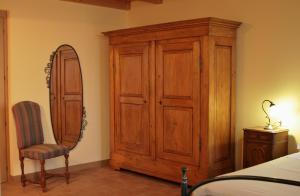 洛迪卡维瑞格农庄酒店的一间卧室配有木制橱柜、椅子和镜子