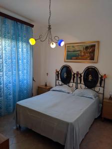 拉卡莱Casa Della Nonna的一间卧室配有一张带蓝色窗帘和吊灯的床。