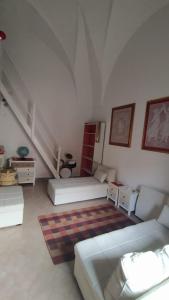 拉卡莱Casa Della Nonna的一间带两张床和楼梯的客厅