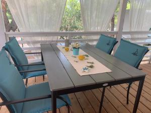 耶泽拉LunaSky Murter Mobile Home的一张桌子,上面摆放着蓝色的椅子和橙子