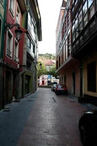 里瓦德塞利亚Pensión Argüelles的大楼一侧的小巷,有车辆停放