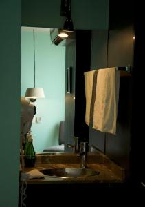 奥里萨巴卢西塔尼亚套房公寓式酒店的一间带水槽、镜子和毛巾的浴室