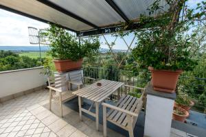 维泰博Axia Terme B&B, 4 min dal Centro Storico - PARK privato的植物阳台的桌椅