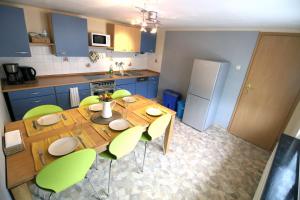 温特贝格Ferienhaus Winterberg-Zentrum的厨房配有木桌和绿色椅子