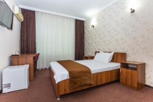 泰尔梅兹Asson Hotel Termez的配有一张床和一张书桌的酒店客房