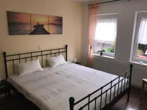 珀丽Ferienwohnung Egerten的一间卧室配有一张带白色床单的床和两个窗户。