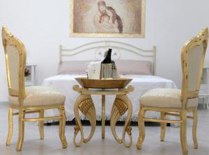 佩兹迪格雷科De Mola Holiday House的一间卧室配有一张带桌子和两把椅子的床