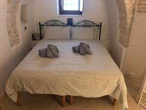马丁纳弗兰卡I Trulli della NaturaBio的一间卧室配有一张床,上面有两条毛巾
