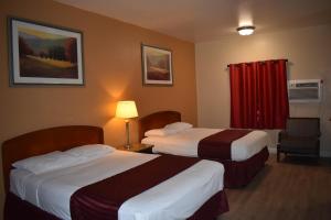 埃尔卡洪El Cajon Inn & Suites的酒店客房设有两张床和红色窗帘
