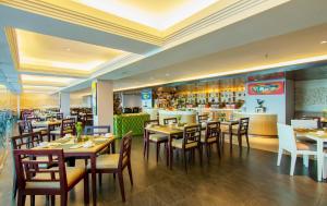 库塔库塔宾唐酒店的一间带桌椅的餐厅和一间酒吧