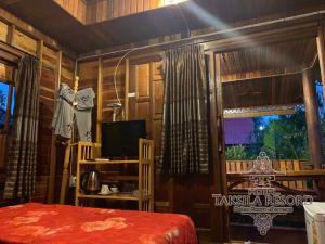 Ban Nong LupTaksila Resort ฏักร์ศิลารีสอร์ท的一间卧室配有一张床、一台电视和一个窗口
