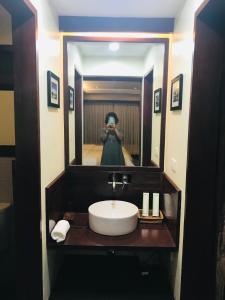 卢纳将军城Retreat Siargao Resort的一位在浴室里拍下水槽照片的女人