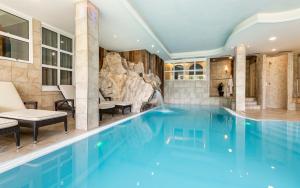 欧缇莫Familienhotel Viktoria的一座带岩石墙的酒店游泳池