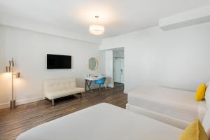 迈阿密海滩总统别墅酒店的白色的客房配有一张床和椅子