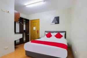 马尼拉OYO 190 Anglo Residences的一间卧室配有一张带红色枕头的大床