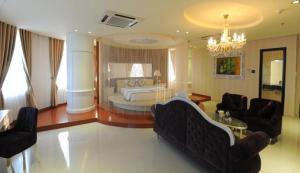 槟知越南Uc酒店的一个带一张床和吊灯的大客厅