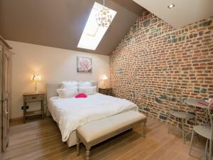 马尔什昂法梅讷Magnificent character cottage with hot tub的一间卧室设有砖墙和一张床