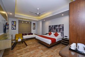 新德里Staybook Hotel Nitya Maharani, New Delhi, Paharganj的酒店客房,配有床和沙发