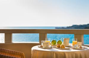 波尔托罗Remisens Hotel METROPOL的一张桌子,上面摆放着食品和饮料,并享有海景