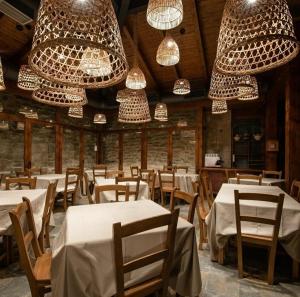 拉瓜迪亚Pensión Biazteri的一间设有白色桌子和吊灯的用餐室