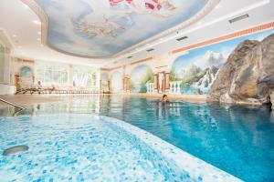 索尔达波斯特健康酒店的一座酒店游泳池,天花板上画着画