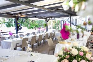 蒙泰马尔恰诺Tenuta Villa Colle Sereno的一间设有白色桌椅和鲜花的餐厅
