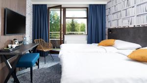 SněžnéOREA Resort Devět Skal Vysočina的酒店客房设有两张床、一张桌子和一台电视。