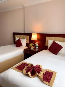 阿吉曼Hala Inn Hotel Apartments - BAITHANS的酒店客房 - 带两张带红色枕头的床