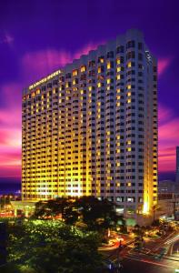 马尼拉Diamond Hotel Philippines的一座在晚上有灯的大建筑
