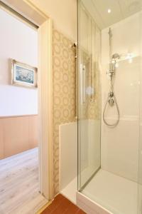 卢加诺维多利亚欧拉克酒店的浴室里设有玻璃门淋浴