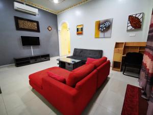 Cukai阿美拉民宿的客厅配有红色沙发和电视