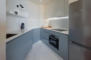 扎鲁亚斯ATeRIAN MUSKARIA的厨房配有白色橱柜和冰箱。