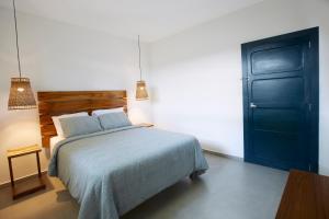 松索纳特Villavela Hotel Boutique的一间卧室配有一张床和一个蓝色的门