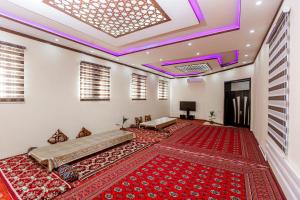 希瓦Xurshidabonu Guest House的一间铺有红色地毯的客房和紫色灯的天花板