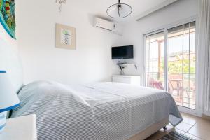 萨索斯安松公寓式酒店的白色的卧室设有床和窗户