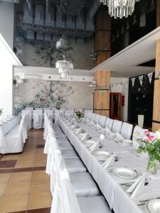 卢巴瓦新城Hotel Tiffany的宴会厅配有白色的桌子和白色的椅子