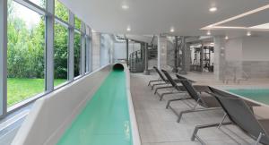 哈利法克斯Residence Inn by Marriott Halifax Dartmouth的一个带椅子和滑梯的室内游泳池
